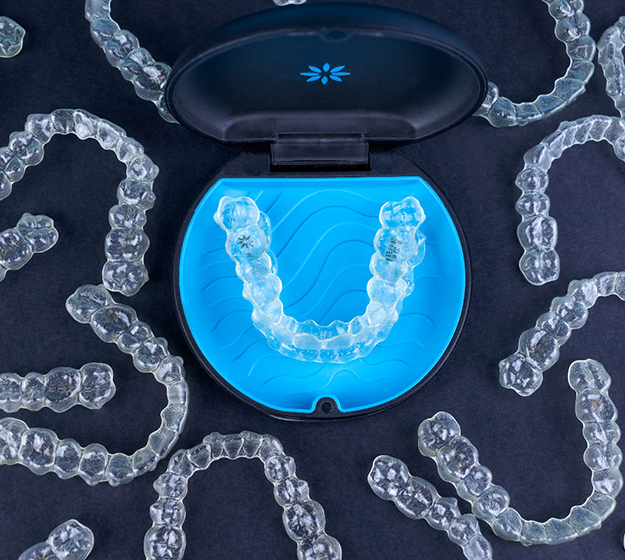 Invisalign aligners in case with other aligners on table
